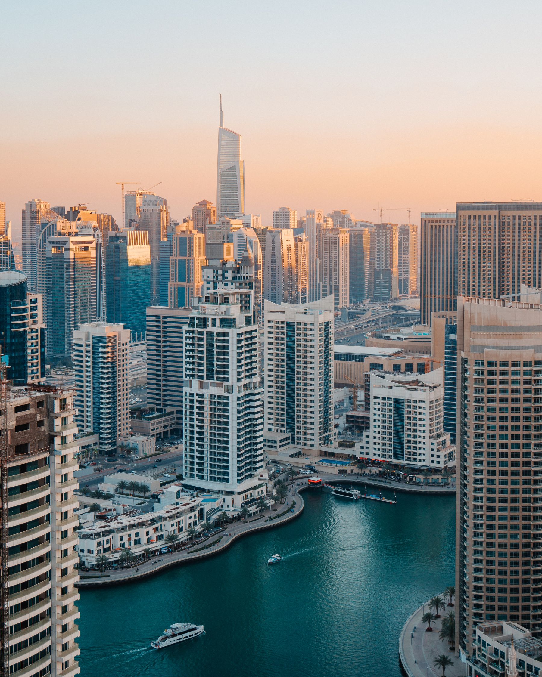 Dubai Marina skyline at dusk, with high-rise buildings reflected in the water